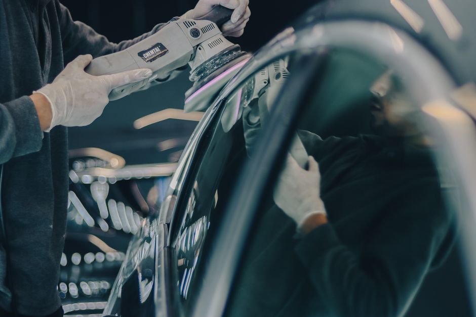 Professional auto detailer carefully working on a vehicle's exterior